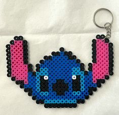 a blue and pink beaded keychain with an earring hanging from it