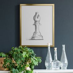 a white table topped with vases next to a plant and painting on the wall