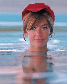 a woman in the water wearing a red hat