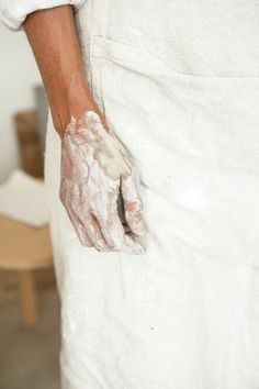 a person with dirty hands holding something in their left hand and wearing white gloves on it