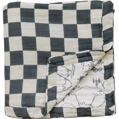 a black and white checkered blanket with an animal design on the front, rolled up in half