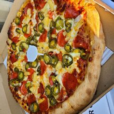 a pizza with pepperoni, jalapenos and cheese in a box