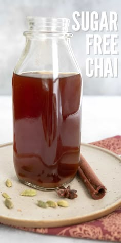 a glass jar filled with liquid sitting on top of a plate next to cinnamon sticks