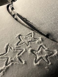 an image of snow written in the snow with stars and arrows drawn on it's surface