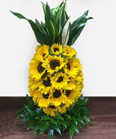 a vase filled with yellow flowers on top of a wooden table