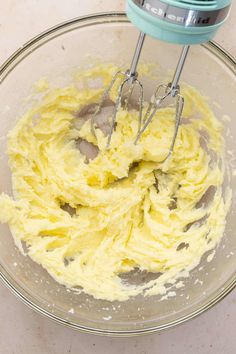 a mixing bowl filled with yellow batter on top of a counter