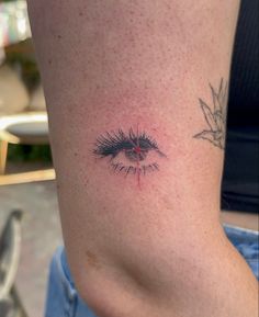 a close up of a person's stomach with an eye tattoo on the side