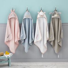 four towels hanging on the wall next to a bench