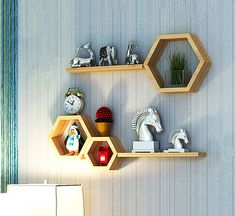 three wooden shelves on the wall with various decorations and figurines in front of them