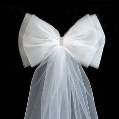 a white veil with a bow on the top is shown in front of a black background