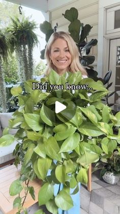 a woman standing next to a potted plant