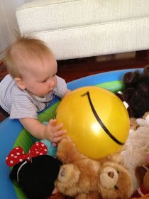 a baby sitting in a chair with a yellow ball