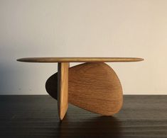 a wooden table sitting on top of a hard wood floor next to a white wall