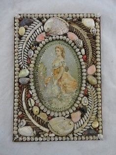 a decorative tile with shells and seashells around it on a white wall background