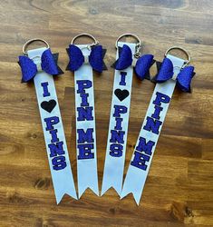 four purple ribbon keychains with i love pink and blue ribbons attached to them