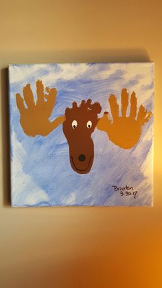 a painting of a moose's head with his hands painted on the wall above it