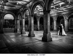 a bride and groom standing in the middle of an old building with arches on either side