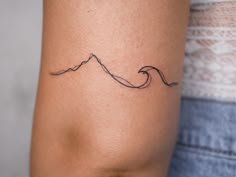 a woman's arm with a small wave tattoo on the left side of her arm