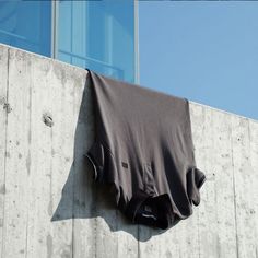 a black shirt hanging on the side of a building