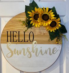 a wooden sign that says hello sunshine and two sunflowers on the front door