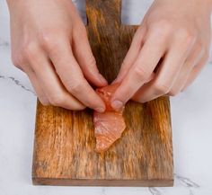 a person is peeling fish on a cutting board