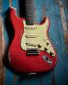 an old red electric guitar lying on a blue wooden floor stock photo getty images