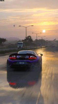 a car driving down a wet road at sunset or dawn with the sun in the background