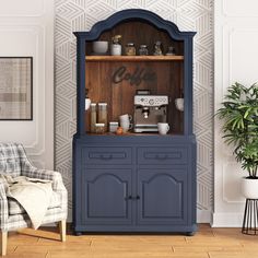 a blue hutch sitting in the corner of a room next to a chair and potted plant