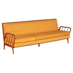 a yellow couch sitting on top of a wooden frame