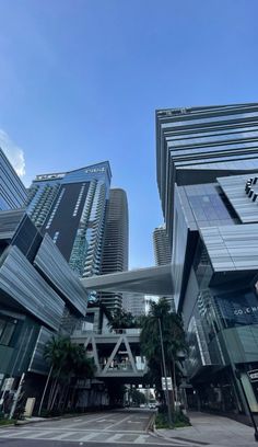 an empty street in front of some very tall buildings