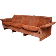 a brown couch sitting on top of a wooden table