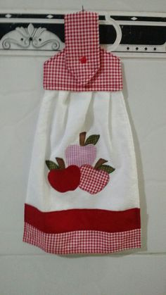 a white and red dress with an apple applique on it