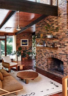 a living room filled with furniture and a fire place in the middle of an open floor plan