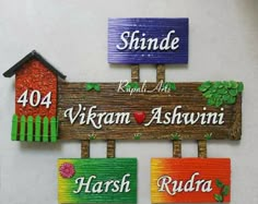 three wooden signs are hanging on the wall in front of a house and another sign that says, shinde