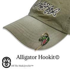 a green hat with an alligator hook on it