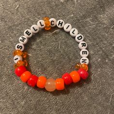 an orange and white beaded bracelet with words on it that read me, my children