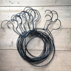 a bunch of black wire sitting on top of a wooden floor