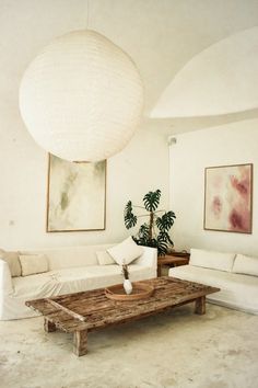 a living room filled with furniture and a large white ball hanging over the top of it