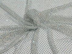 the fabric is made up of many small dots and silver beads on white mesh material