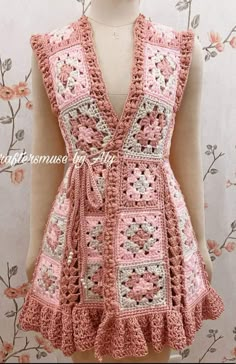 a pink crocheted vest with flowers on it