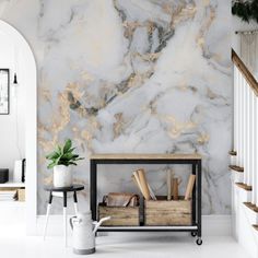 a white and gold marbled wall in a living room next to a stair case