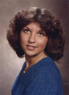 an old photo of a woman wearing a blue sweater