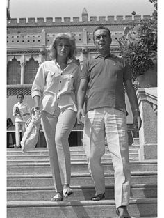 a man and woman walking down some steps