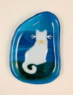 a blue glass plate with a white cat on it