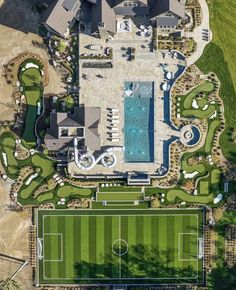 an aerial view of a large house with a soccer field in the foreground and a swimming pool on the far side