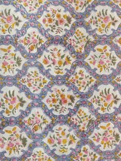 a blue and yellow floral print fabric with small pink flowers on it's sides