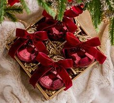 a box with red ornaments on top of a white blanket