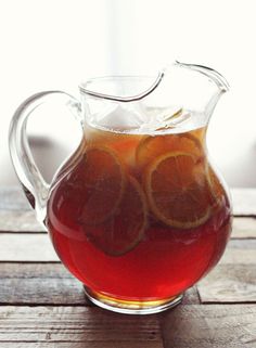 a pitcher filled with liquid sitting on top of a wooden table