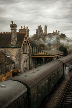 an old train traveling down tracks next to a building