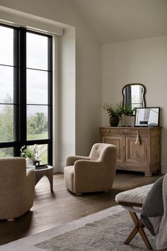 a living room filled with furniture next to a large window covered in lots of windows